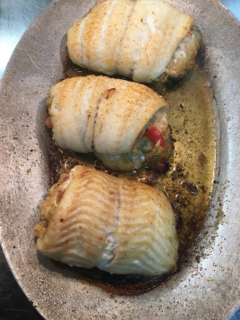 Fried flounder beside hushpuppies